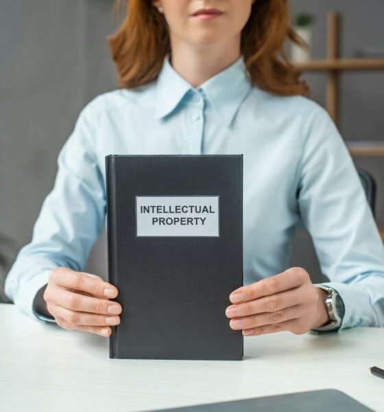 Cropped view of female lawyer showing book with intellectual property lettering, while sitting at